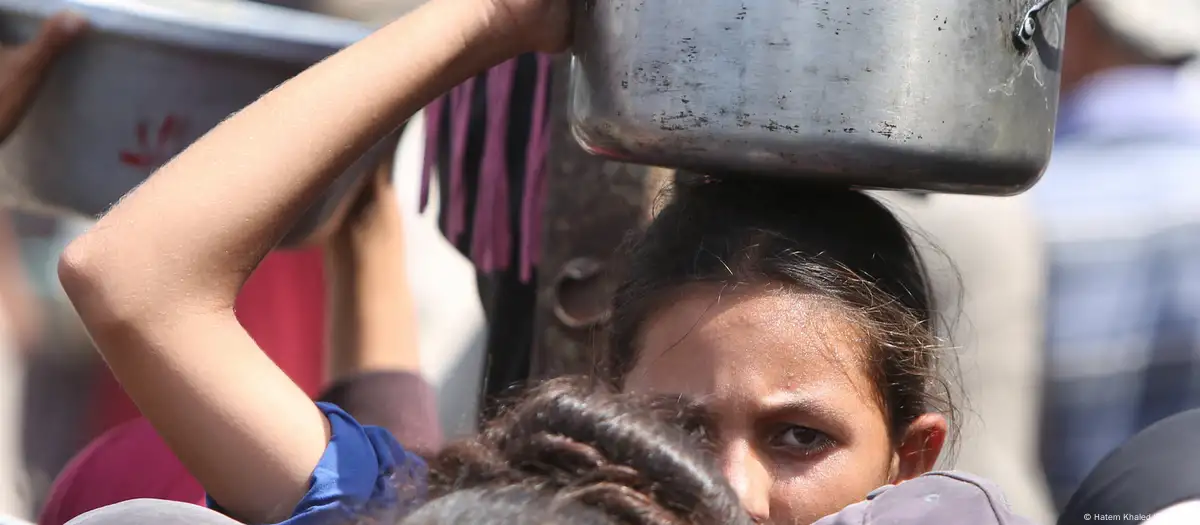 Una niña palestina espera para recibir ayuda alimentanria en Jan Yunis.